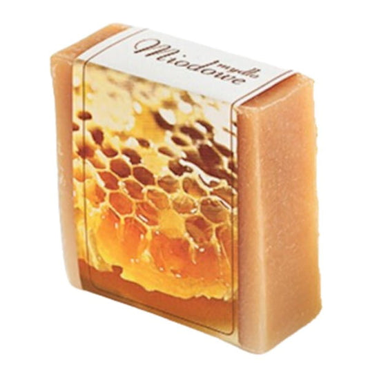 Naturseife von KORANA mit Honig, 100 g, zeigt eine weiße Seife auf einem Holztablett, ideal für sanfte Hautpflege.