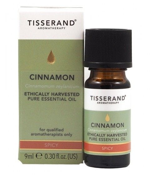 Ethisch geerntetes Zimtöl von TISSERAND, 9 ml Flasche, zeigt Zimtstangen und ätherisches Zimtöl in einem Glasbehälter.
